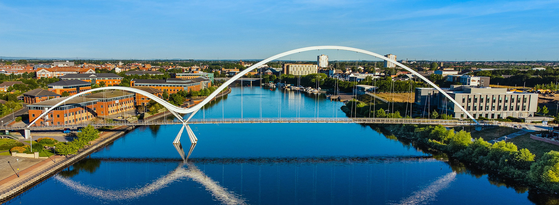 The image features a cityscape with a river running through it, a bridge spanning across the water, and a clear sky above.